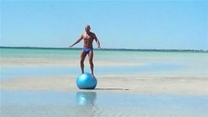 Man balancing on exercise ball.